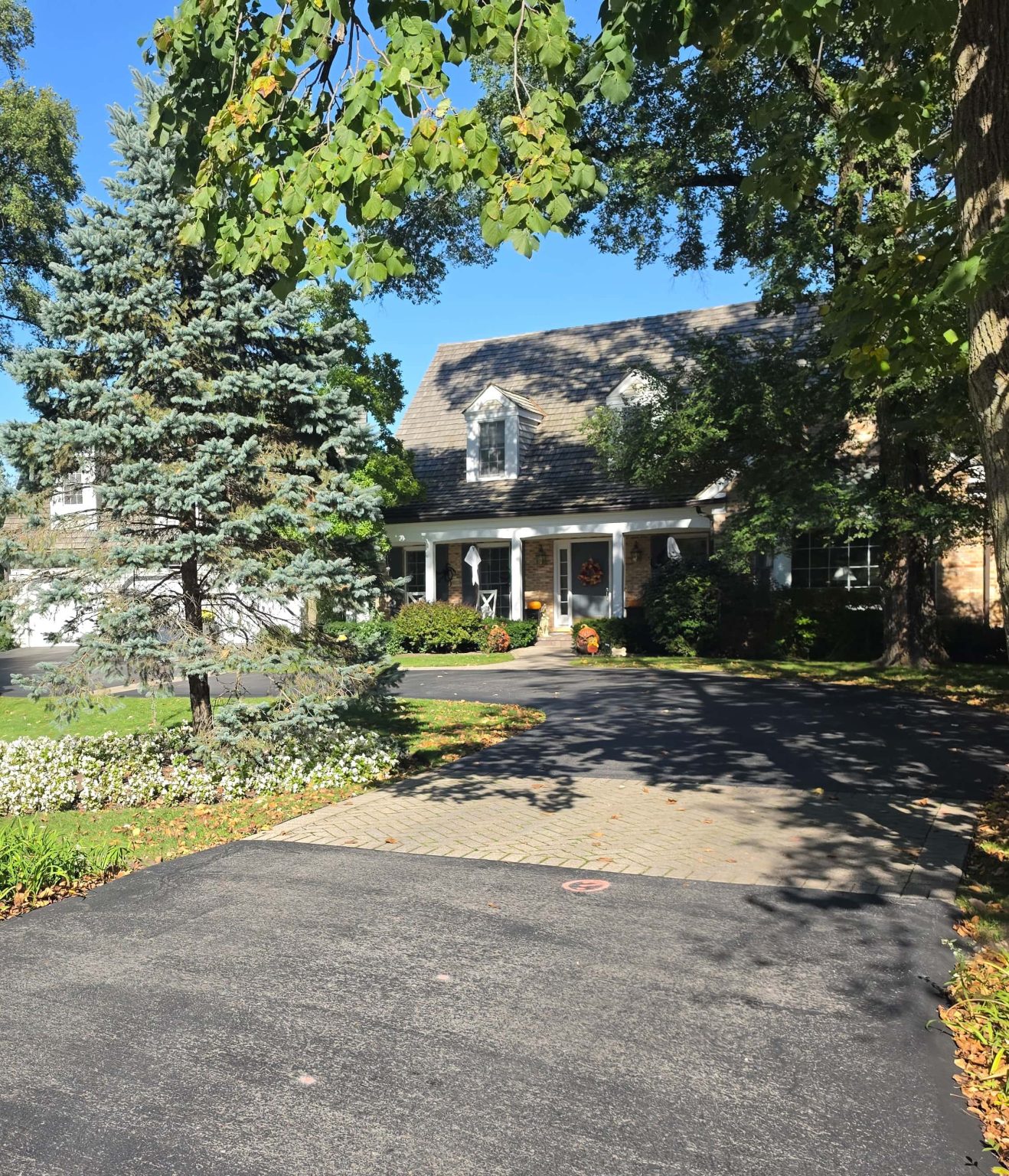 Home set back behind a curved driveway, landscaped planting beds and mature trees in Bannockburn.