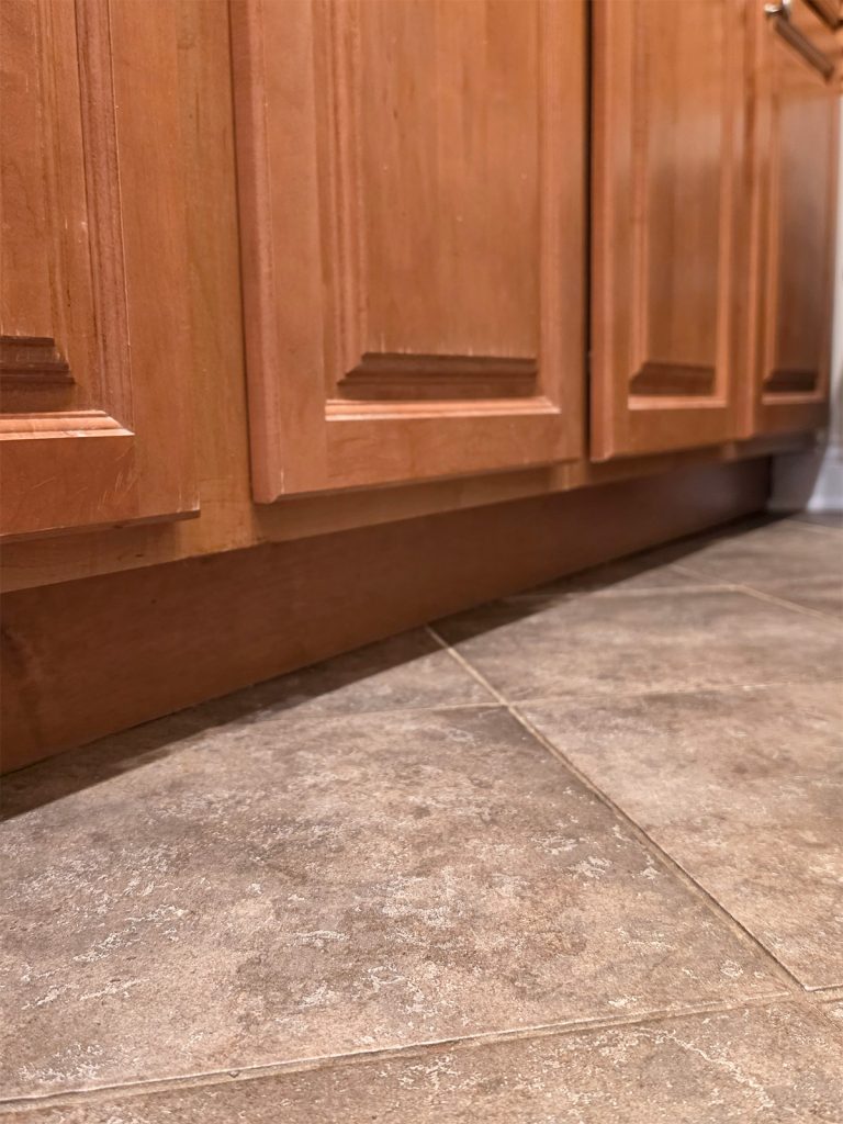 Kitchen cabinet toe-kick and floor line reviewed during cockroach control service