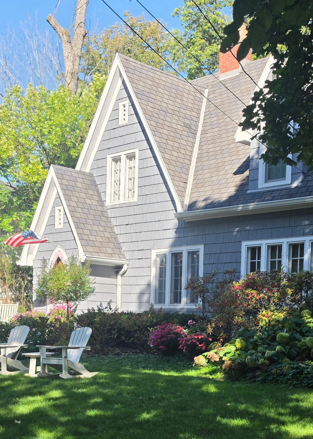 Gray gabled home with a flowering front garden and white picket fence in Deerfield.