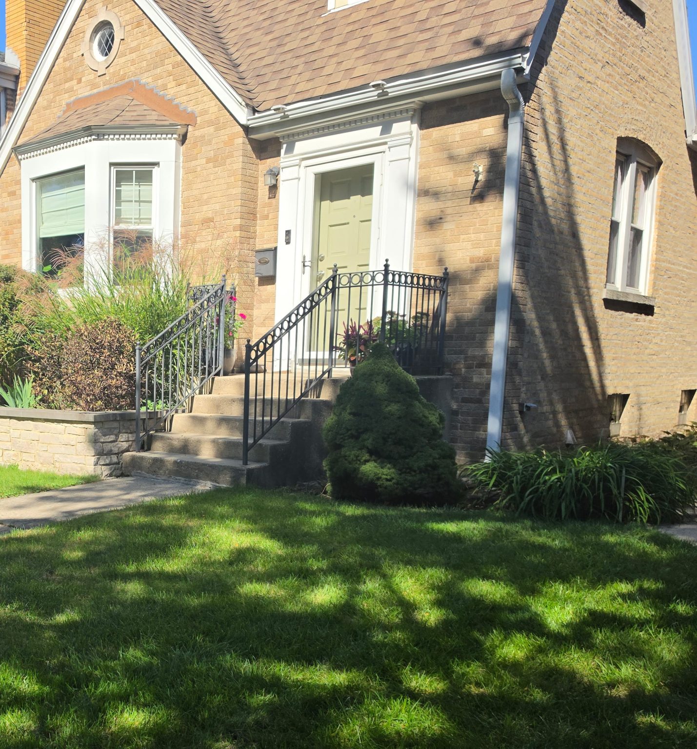 Brick homes with bay windows, front steps and landscaped lawns in Forest Glen.