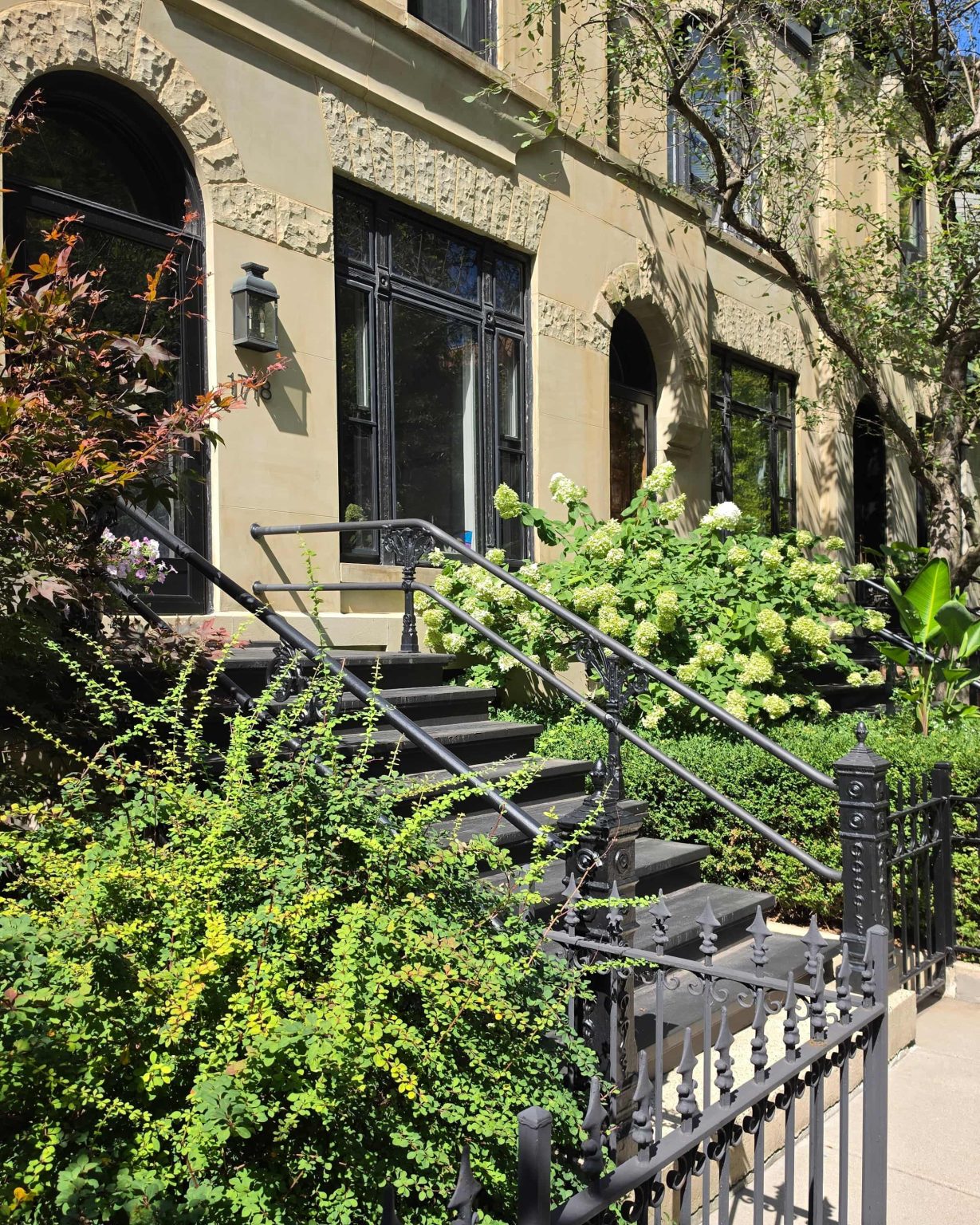Stone residential frontages in Lincoln Park, Chicago, with arched entrances, stairs, railings, and landscaped front yards.