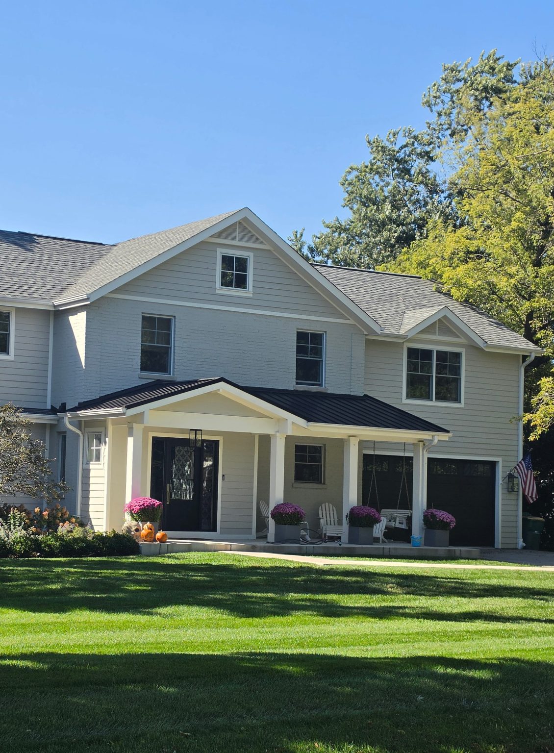 Two-story home with a covered front porch, broad lawn and mature trees in Northfield.