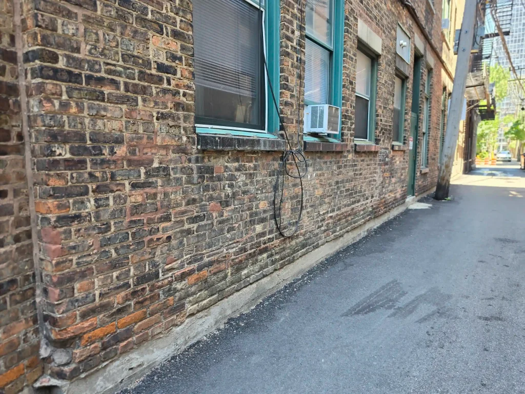 Exterior brick wall, gas meter, and planting bed along the foundation reviewed during rat control service