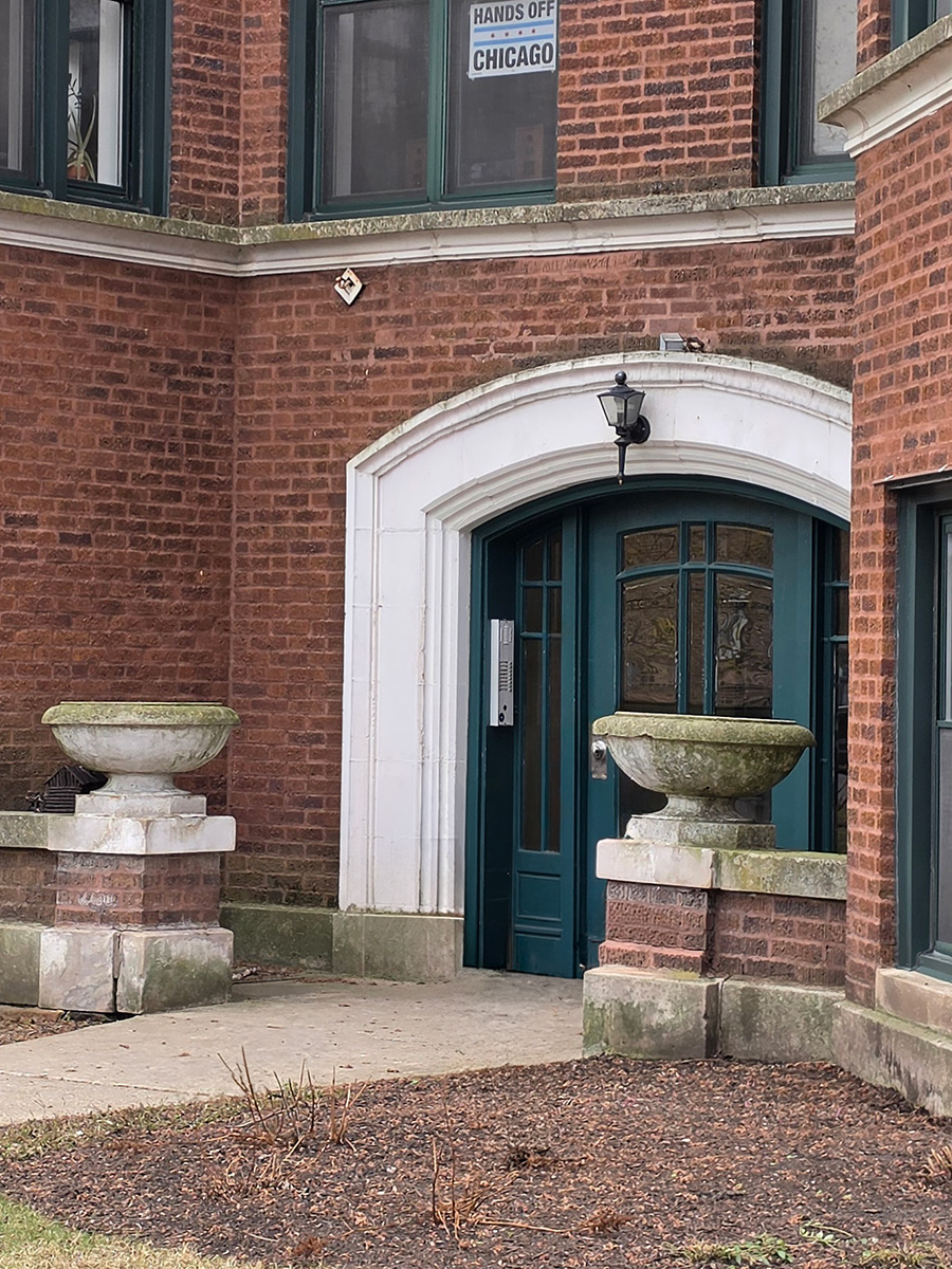 Brick multi-unit residential building in Rogers Park, Chicago, with projecting bays, an arched entrance, and masonry detailing.