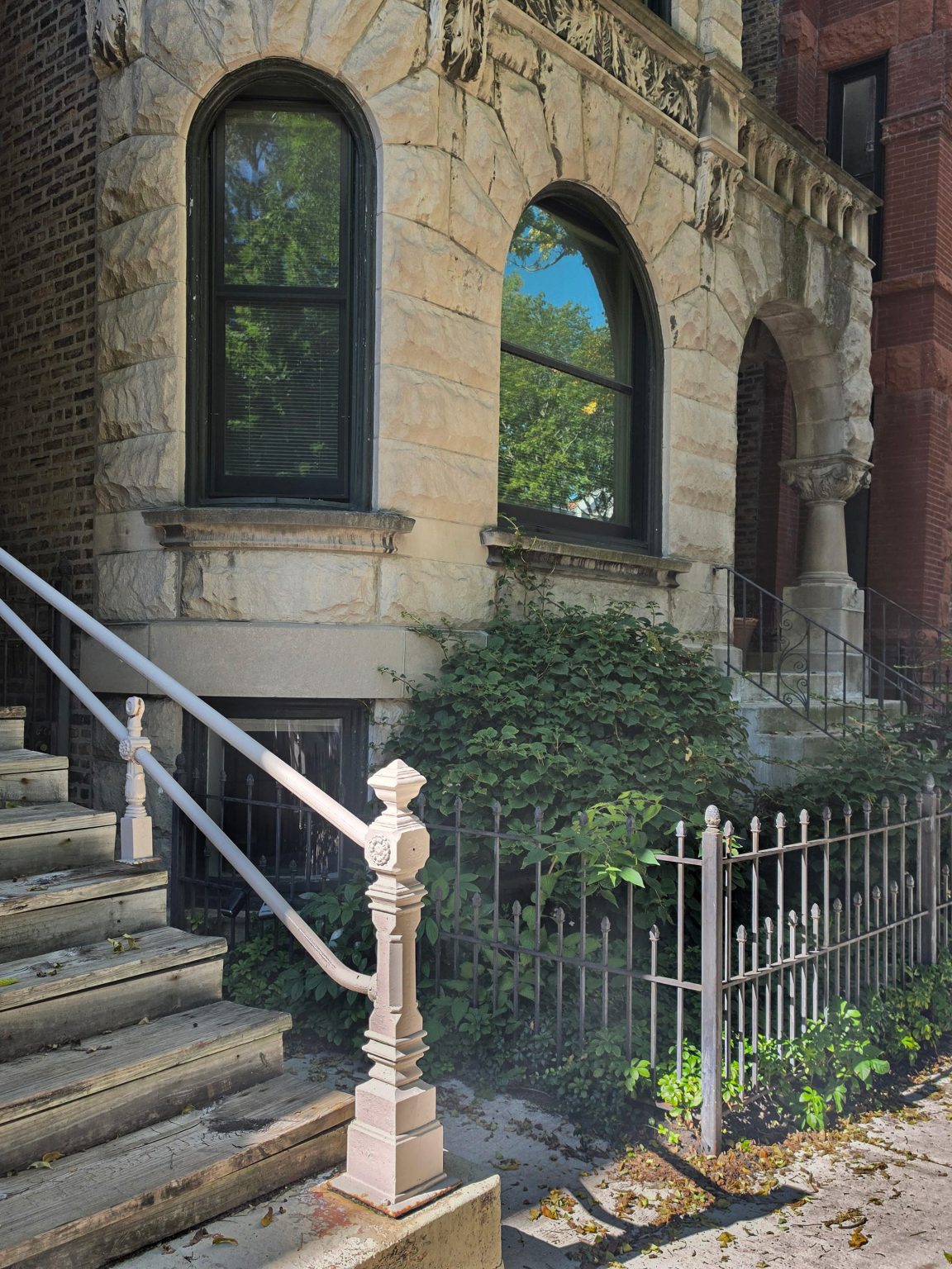 Stone residential façade with arched windows and an arched entrance in Ukrainian Village.