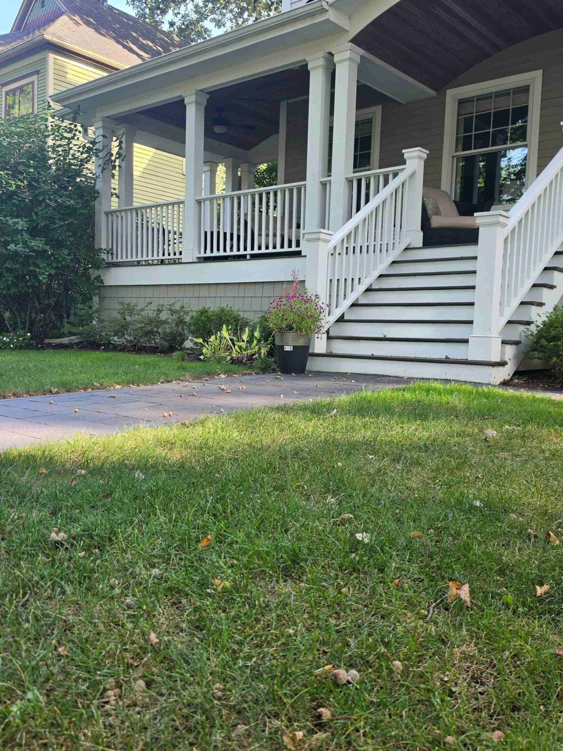 Residence in Wilmette, Illinois, with a broad covered front porch, landscaped yard, and neighboring residential architecture.