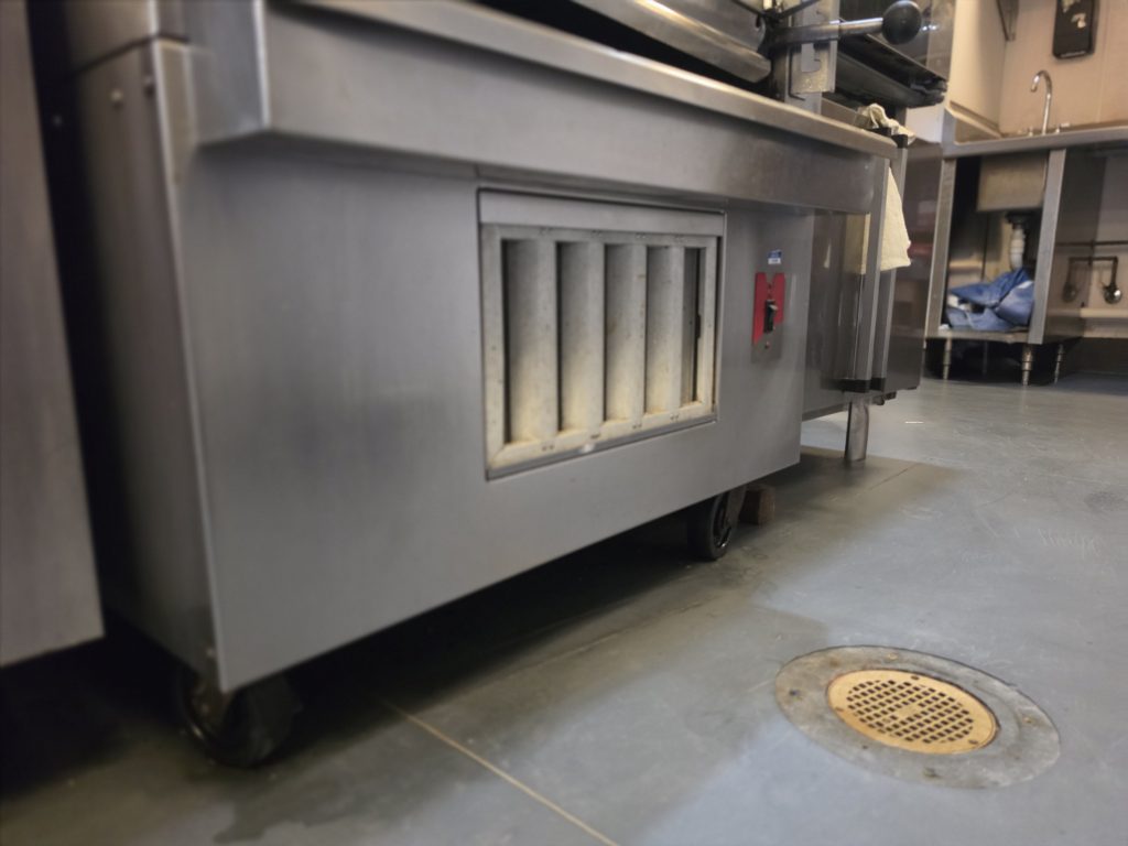 Commercial restaurant equipment and surrounding floor area.