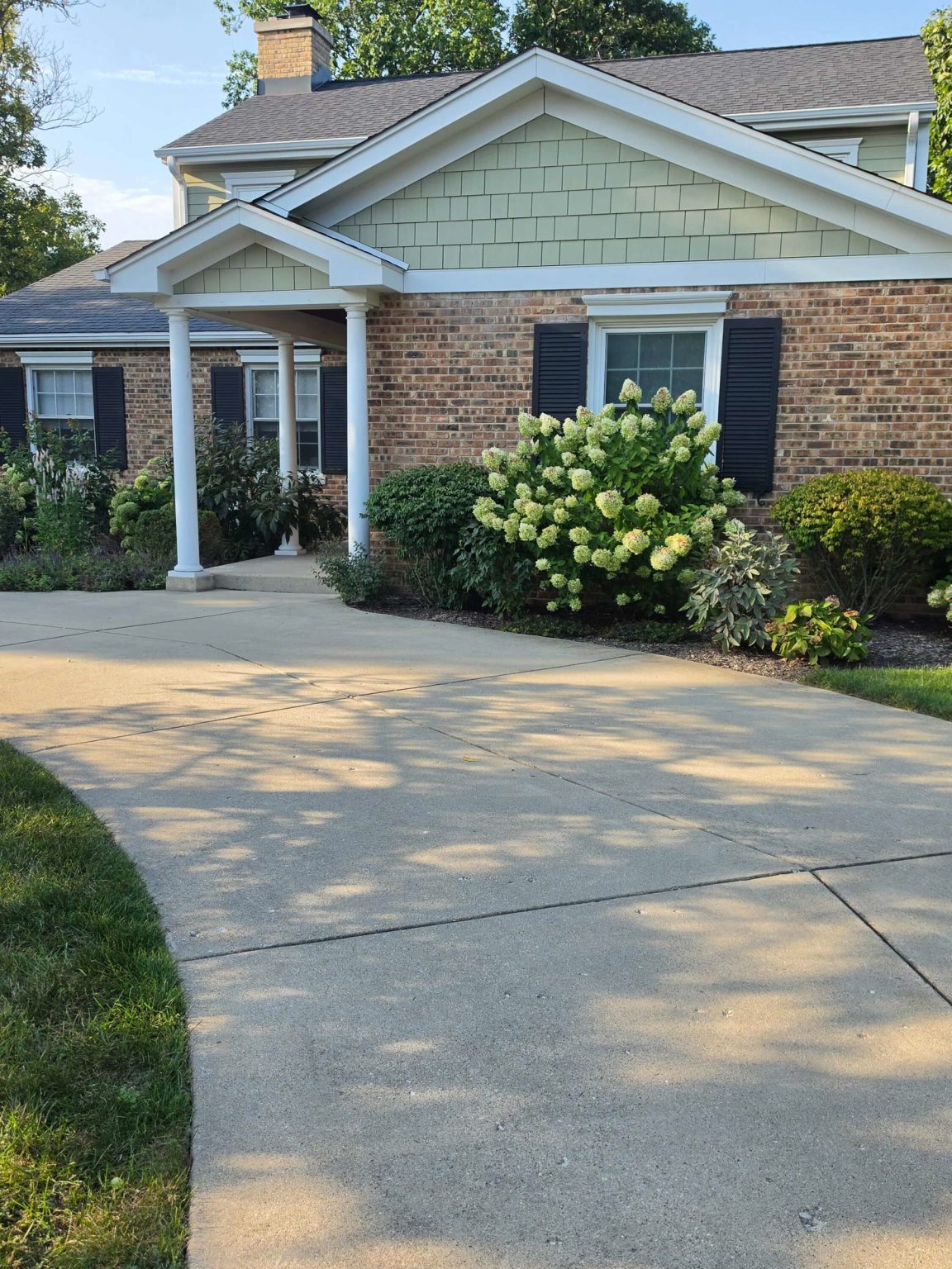 Brick and siding split-level residence in Glenview, Illinois, with mature landscaping, an attached garage, and a broad residential driveway.