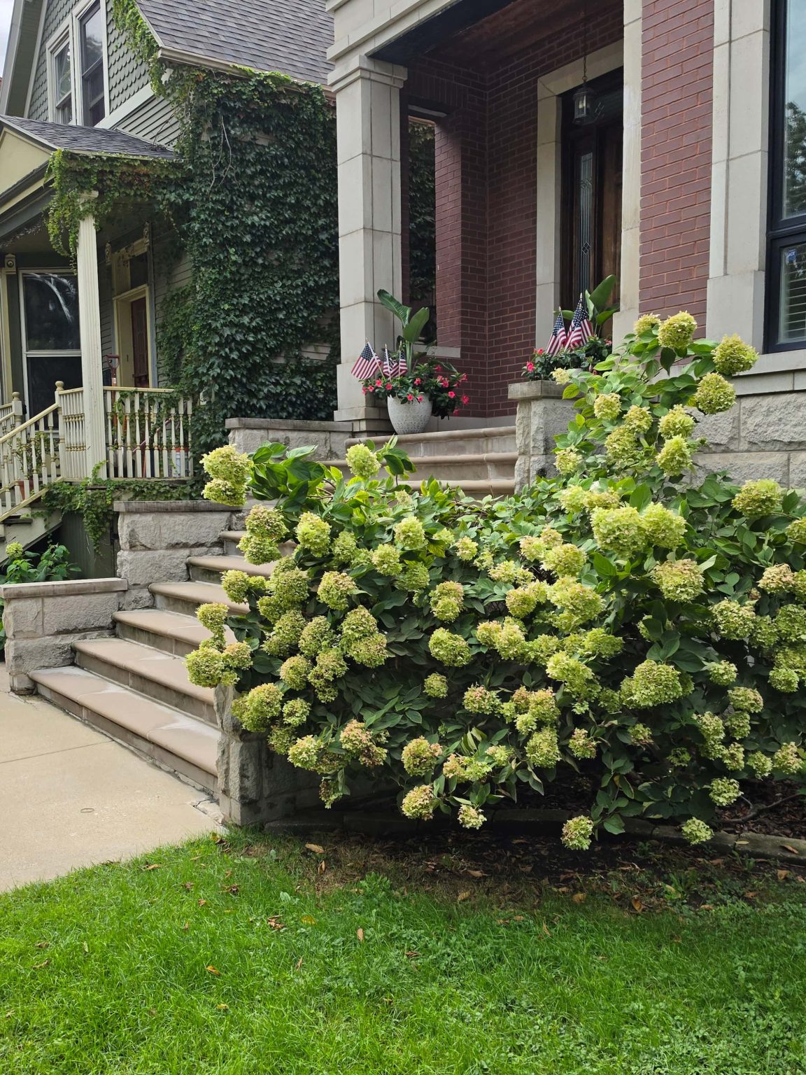 Brick house with stone entrance columns and front landscaping in Logan Square, Chicago.