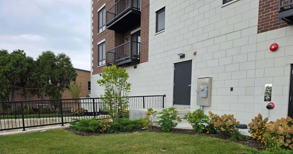 Multi-unit building with balconies, lawn and landscaped beds in Niles.
