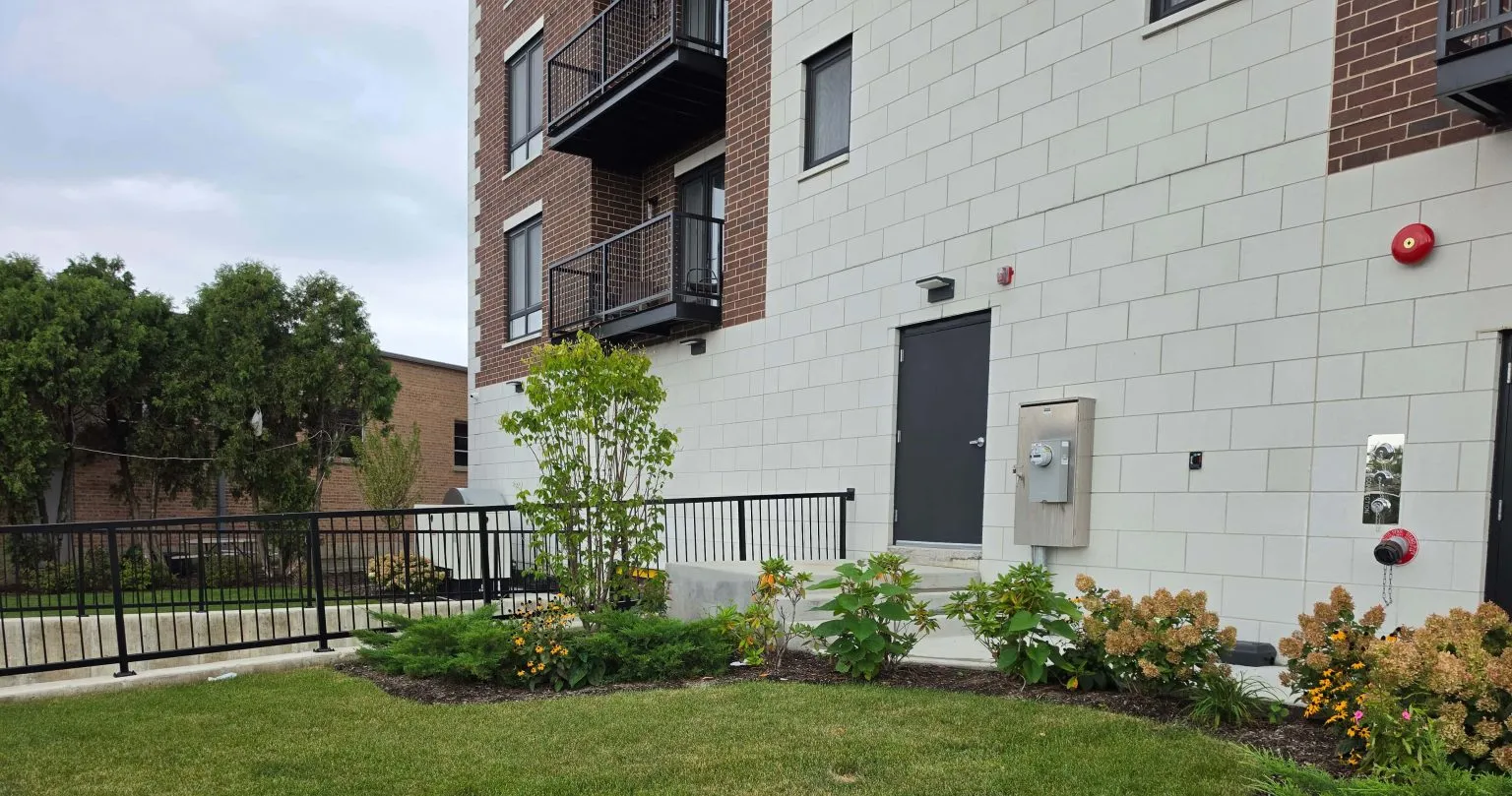 Multi-unit building with balconies, lawn and landscaped beds in Niles.