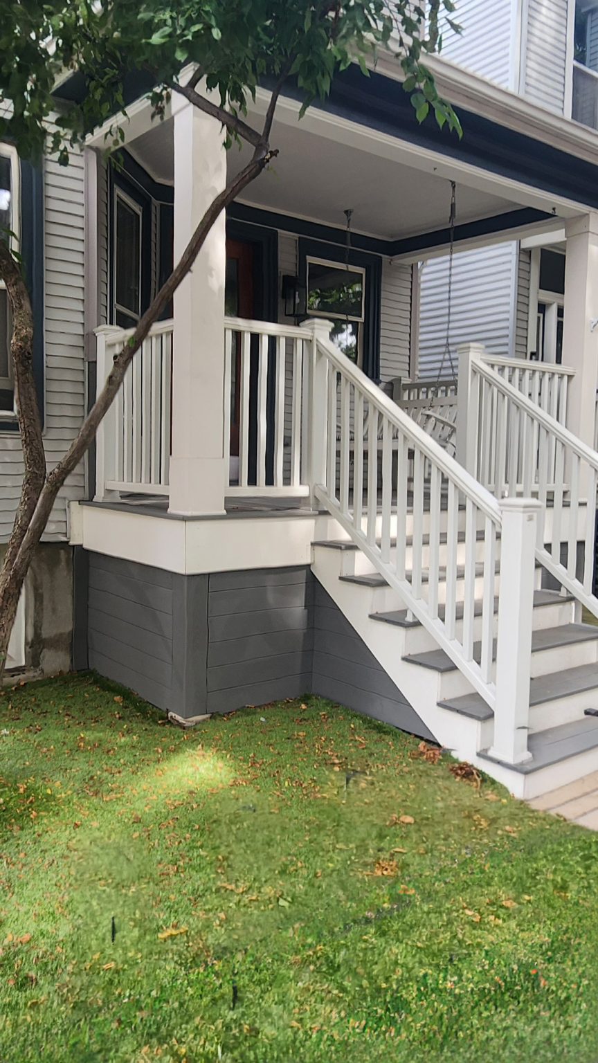 White front porch and steps beside a lawn at a North Center home.