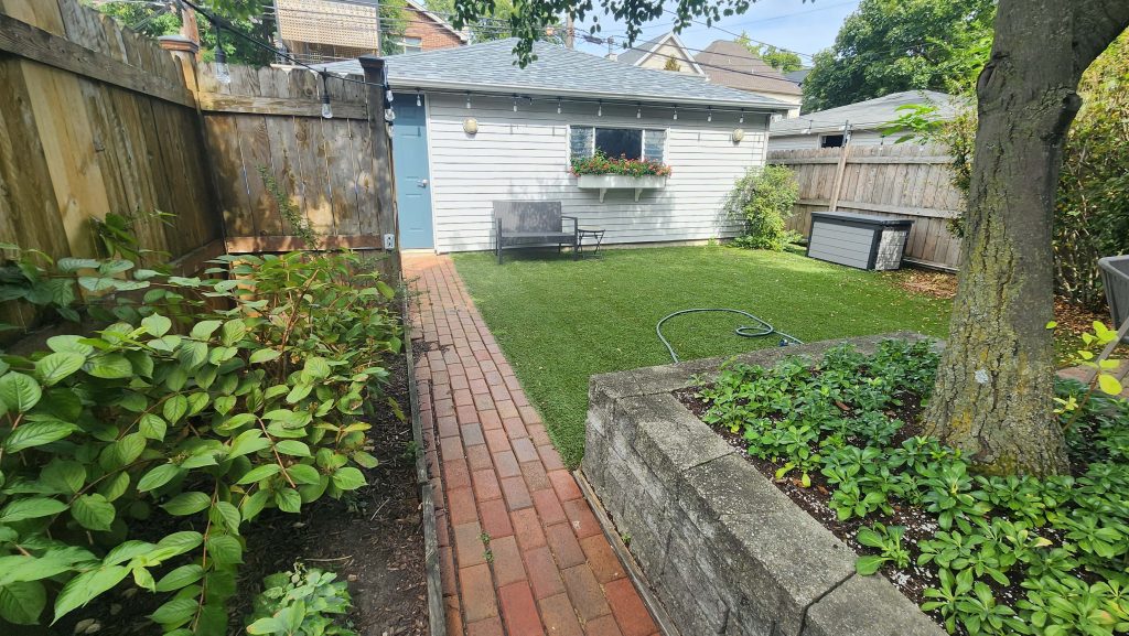 Rear lawn, planted tree bed and garage.