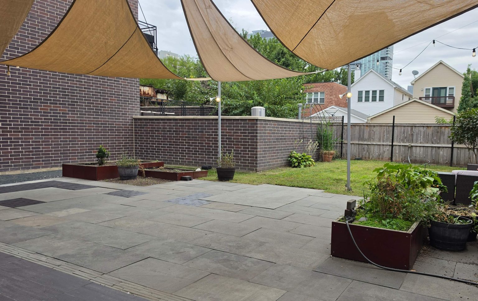 Backyard lawn, raised planting beds and paved patio in Old Town.