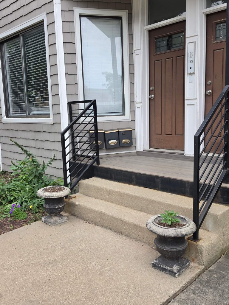 Residential front steps, entrance doors and planters.