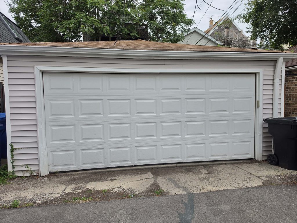 White garage door and adjacent paving.