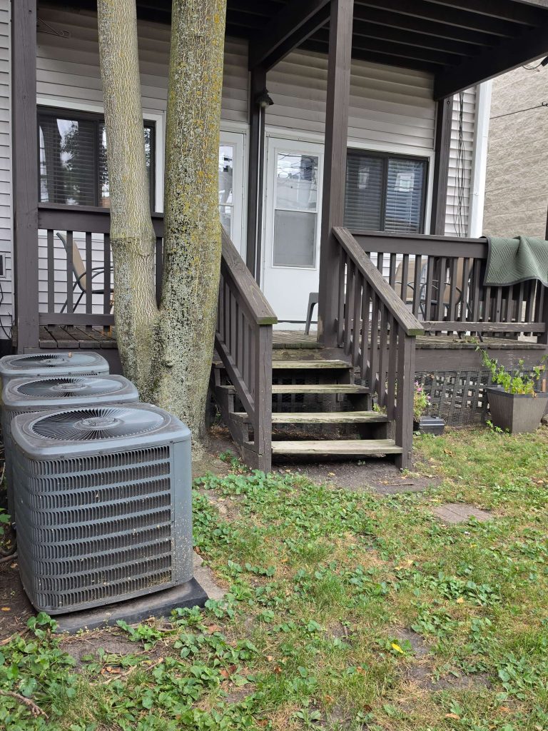 Wooden rear deck, stairs and outdoor air-conditioning units.