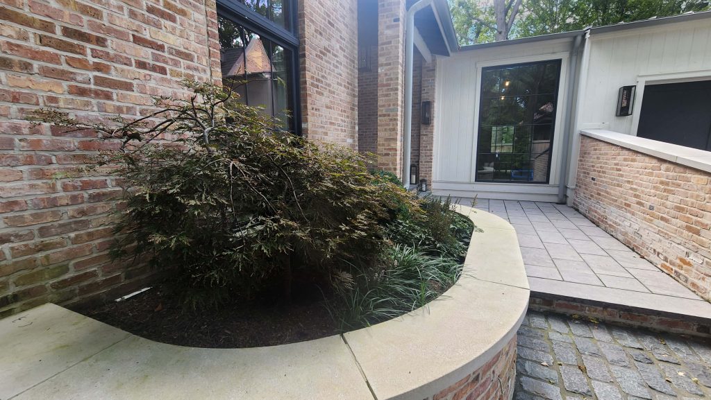 Brick home and curved raised planting wall in Winnetka.